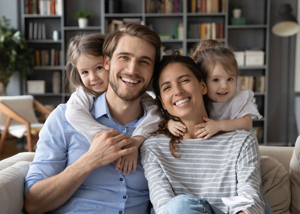 young family smiling on couch
